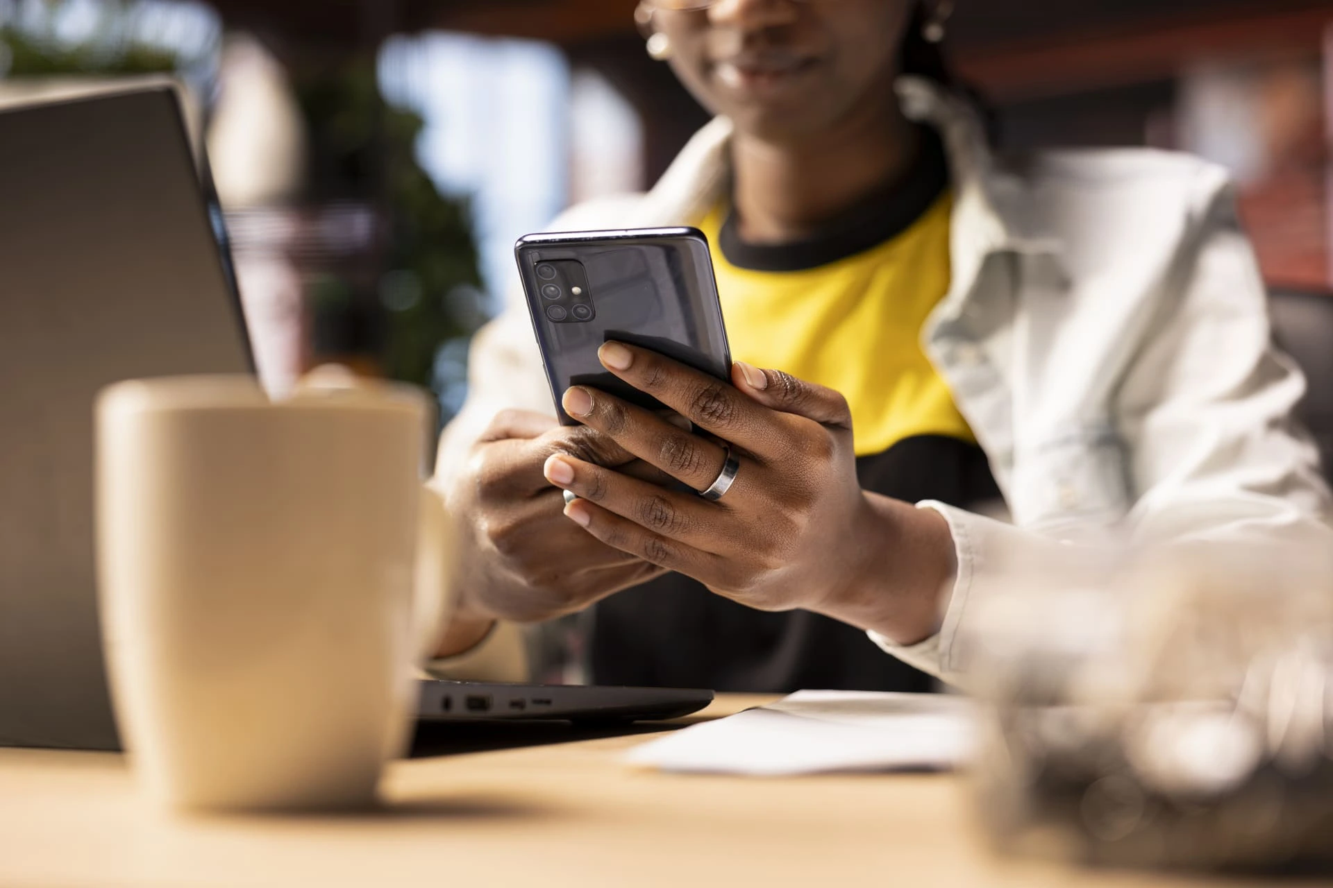 Femme assise à son bureau tenant son téléphone dans les mains